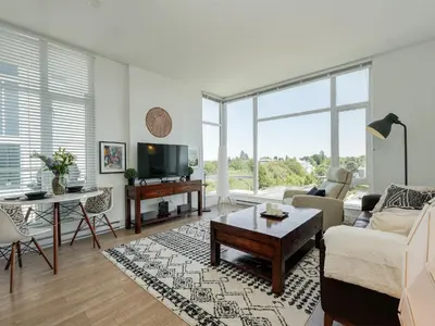 a living room with a couch and a table at The Bohemian, min 30-Day Stay with Breathtaking Views and Home Office by Victoria Prime! in Victoria