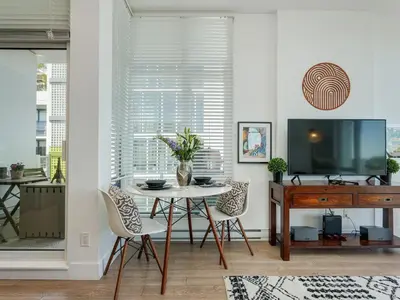 a dining room with a table with chairs and a tv at The Bohemian, min 30-Day Stay with Breathtaking Views and Home Office by Victoria Prime! in Victoria