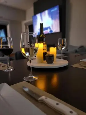 a table with three wine glasses and a bottle of wine at Serenity at Sparrowhawk Lodge Brand New 2Bd 2Ba in Dead Man's Flats