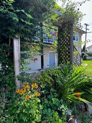 a house with a balcony and flowers in front of it at Upper floor suite with Garden view near SFU & Skytrain in Coquitlam