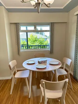 a dining room with a table and chairs and a window at Upper floor suite with Garden view near SFU & Skytrain in Coquitlam