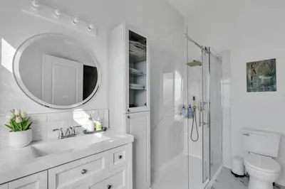 a white bathroom with a sink and a shower at ModernOasis with AC&MovieRoom close to Downtown15' Banff 60' in Calgary