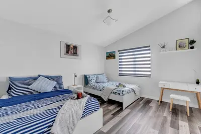 a bedroom with a bed and a desk and a chair at ModernOasis with AC&MovieRoom close to Downtown15' Banff 60' in Calgary