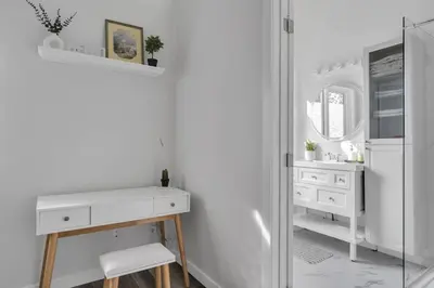 a white bathroom with a sink and a mirror at ModernOasis with AC&MovieRoom close to Downtown15' Banff 60' in Calgary