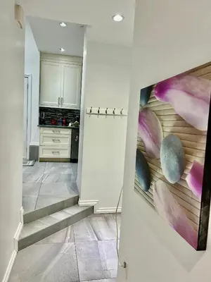 a staircase in a kitchen with a painting on the wall at The warm and lovely coach home in Vancouver