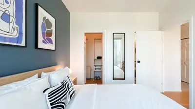 a bedroom with a white bed and a blue wall at Stunning 1-Bedroom Condo in the Heart of Vancouver in Vancouver
