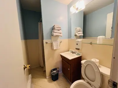 a bathroom with a toilet and a sink and a mirror at Victorian Motel & RV Park by Capital O in Grand Forks