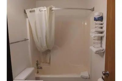 a bathroom with a shower with a shower curtain at Victorian Motel & RV Park by Capital O in Grand Forks