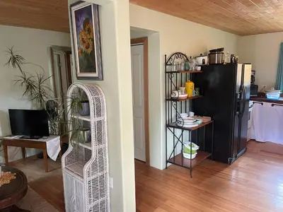 a living room with a black refrigerator and a table at Oysterbeds offers our Oyster Suite in Lund