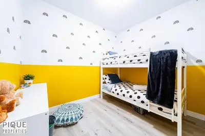 a childs bedroom with yellow walls and bunk beds at Modern Retreat - 3 King Beds - Garage - WiFi - Sleeps 10 in Edmonton
