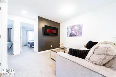 a living room with a couch and a tv at Modern Retreat - 3 King Beds - Garage - WiFi - Sleeps 10 in Edmonton