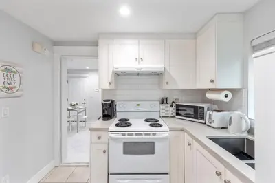 a kitchen with white cabinets and a white stove top oven at Cozy and Modern 2br guesthouse in Vancouver