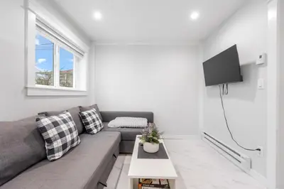 a living room with a couch and a tv at Cozy and Modern 2br guesthouse in Vancouver