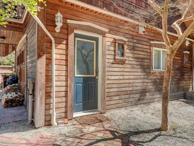 a wooden house with a blue door on it at Fairfield Estate Coach House - 30-Day Stay, steps from Cook Street Village by Victoria Prime! in Victoria