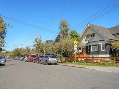 a row of cars parked on the side of a street at Fairfield Estate Coach House - 30-Day Stay, steps from Cook Street Village by Victoria Prime! in Victoria