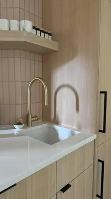 a kitchen with a white sink and two faucets at Skywood-Designer Condo,Steps to Creekside Gondola, Free Parking in Whistler