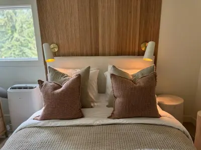 a bedroom with a bed with pillows and a window at Skywood-Designer Condo,Steps to Creekside Gondola, Free Parking in Whistler