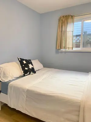 a white bed in a room with a window at Entire 1Bed 1Bath Suite Coquitlam Centre in Port Coquitlam