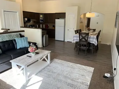a living room and kitchen with a couch and a table at 4br Crew House - Big, Bright, Modern, Fully Stocked in Grande Prairie