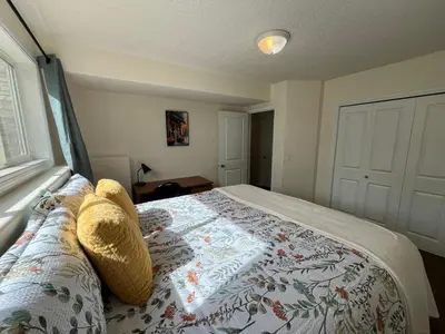 a bedroom with a bed with a blanket on it at 4br Crew House - Big, Bright, Modern, Fully Stocked in Grande Prairie