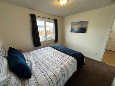 a bedroom with a bed and a window at 4br Crew House - Big, Bright, Modern, Fully Stocked in Grande Prairie