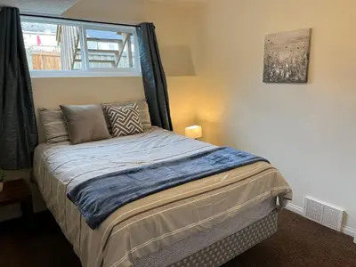 a bed in a room with a window at 4br Crew House - Big, Bright, Modern, Fully Stocked in Grande Prairie