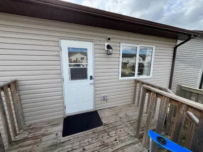 a house with a white door and a porch at 4br Crew House - Big, Bright, Modern, Fully Stocked in Grande Prairie