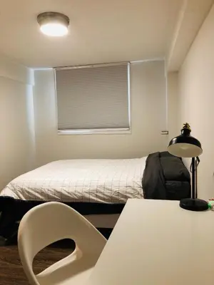 a bedroom with a bed and a table and a lamp at 5th Floor 1 Bedroom Condo with Parking in Calgary