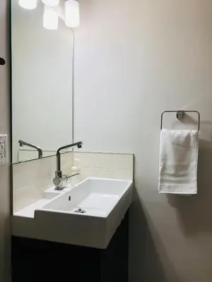 a bathroom with a white sink and a mirror at 5th Floor 1 Bedroom Condo with Parking in Calgary