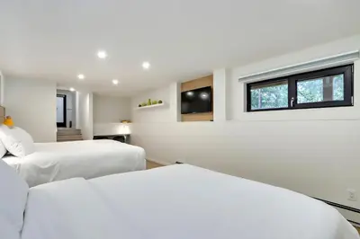 two beds in a white room with two windows at Modern King-Size Guest Suite in Burnaby
