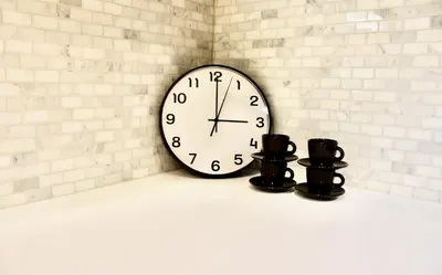 a clock on a wall with two black candles at 2BDR Stylish Comfort Parkside in Vancouver