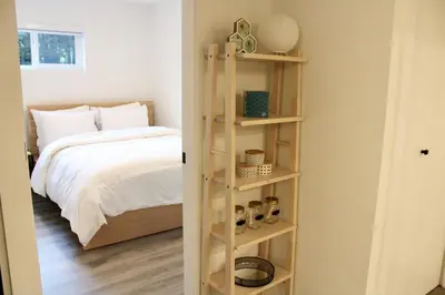 a bedroom with a bed and a book shelf at 2BDR Stylish Comfort Parkside in Vancouver
