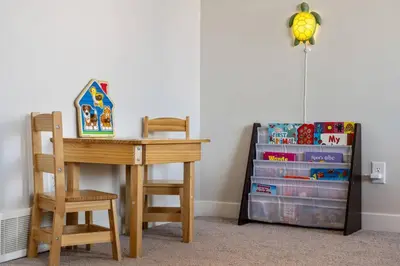 a desk and a chair next to a book shelf at 3 Bedroom Sage House with AC, Driveway Parking, King Bed & More in Calgary