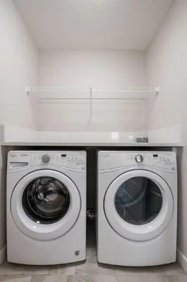 a washing machine and a washer in a room at 3 Bedroom Sage House with AC, Driveway Parking, King Bed & More in Calgary