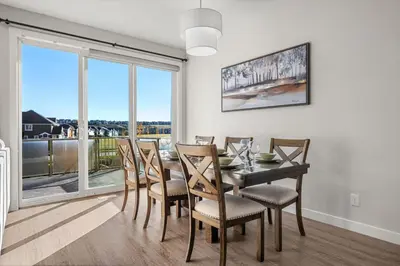 a dining room with a table and chairs and a large window at 3 Bedroom Sage House with AC, Driveway Parking, King Bed & More in Calgary