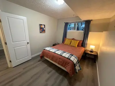 a small bedroom with a bed and a window at Park View Paradise - Big, Bright, Modern, Fully Stocked in Grande Prairie