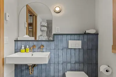 a bathroom with a white sink and a mirror at Otter Hotel in Banff
