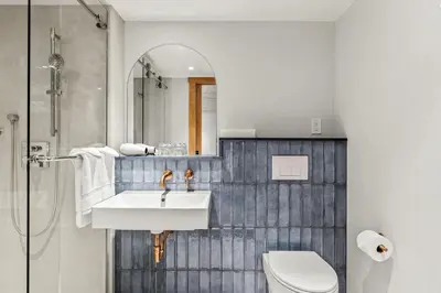 a bathroom with a sink and a toilet and a mirror at Otter Hotel in Banff