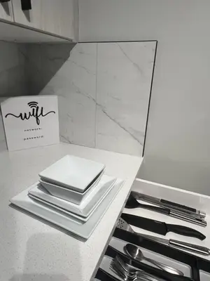 a table with plates and utensils on a counter at Modern 2 bedroom suite in Calgary