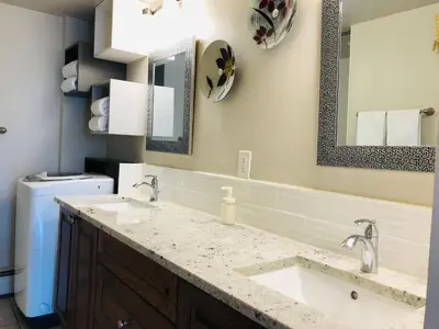 a bathroom with two sinks and a mirror at Cozy 2 Bedroom Condo with Parking in Calgary