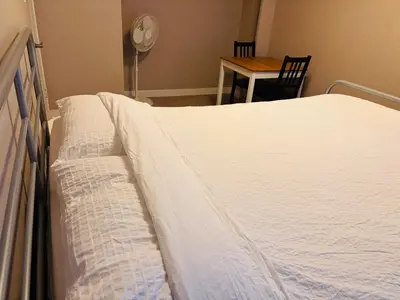 a bed in a room with a table and a chair at 6th Floor 2 Bedroom Condo with Parking in Calgary