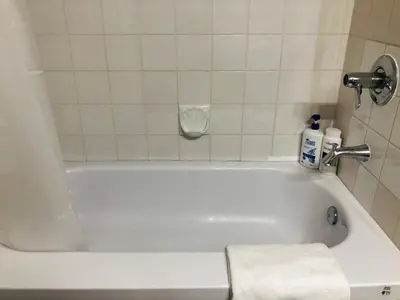 a white bath tub with a towel sitting in it at 6th Floor 2 Bedroom Condo with Parking in Calgary