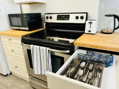 a kitchen with a stove and a microwave at Cozy 1 Bedroom Condo with Parking in Calgary