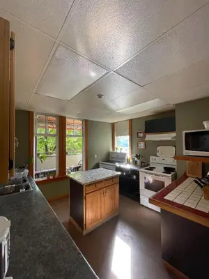 a large kitchen with a stove and a counter top at Mountain Shadow Hostel in Rossland