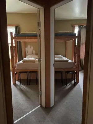 two bunk beds in a room with a mirror at Mountain Shadow Hostel in Rossland