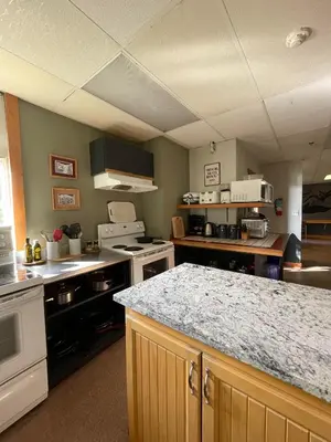 a large kitchen with a counter and a counter top at Mountain Shadow Hostel in Rossland