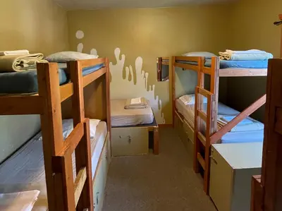a room with three bunk beds in it at Mountain Shadow Hostel in Rossland