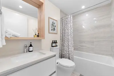 a bathroom with a toilet and a tub and a sink at Brand new Stylists Richmond central 2B2BR in Richmond