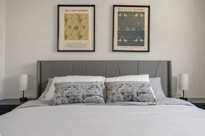 a bedroom with a bed with two pictures on the wall at Spacious 4-Bedroom Retreat Near Bow River with Foosball, Dart Board, Movie Room in Calgary