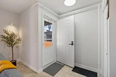 a hallway with a white door and a window at Spacious 4-Bedroom Retreat Near Bow River with Foosball, Dart Board, Movie Room in Calgary